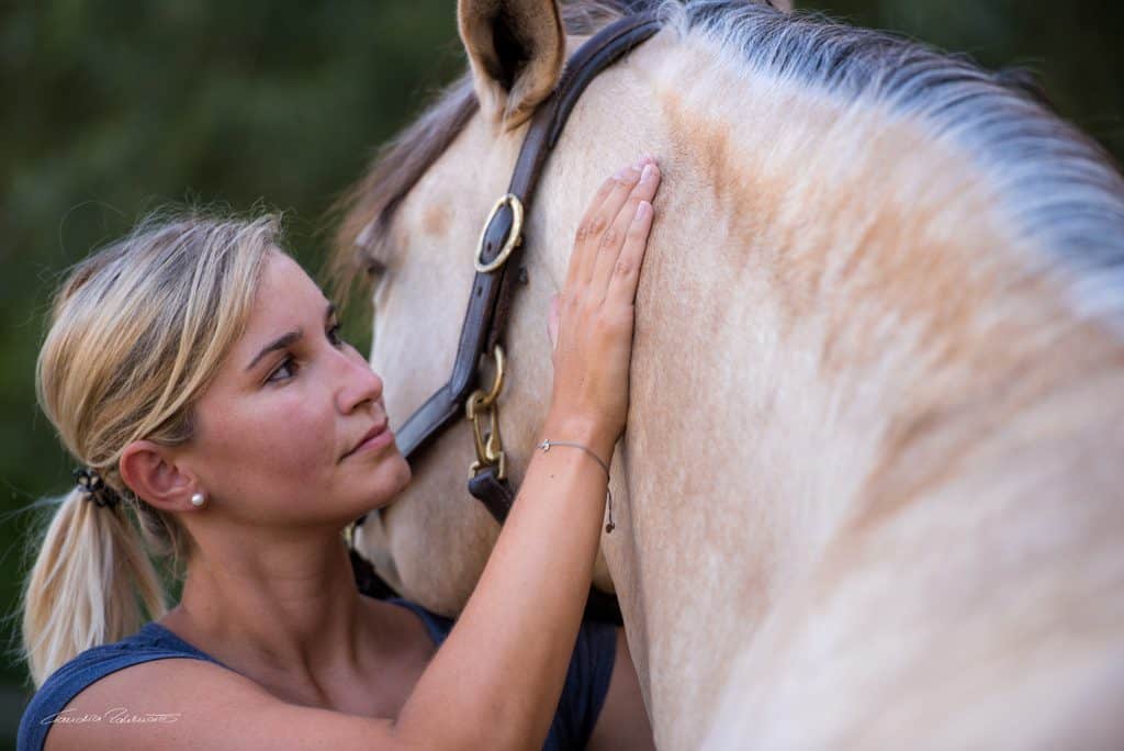 Detailaufnahme Tierphysiotherapeutin Katharina Ludwig behandelt Pferd mit manueller Therapie am Hals